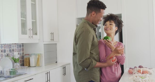 Happy african american couple with vegetables in kitchen. Spending quality time at home together concept.
