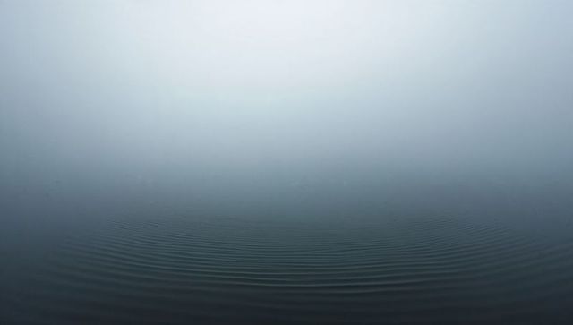 Misty seascape with concentric ripples minimal gradient horizon evoking calm and focus