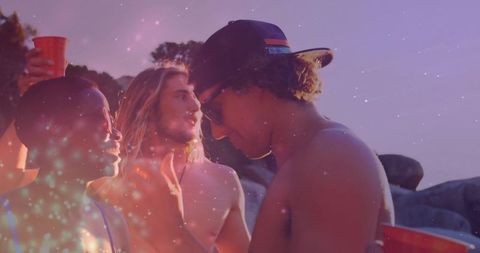 Friends Enjoying Party by Lakeside at Sunset with Glittering Overlay