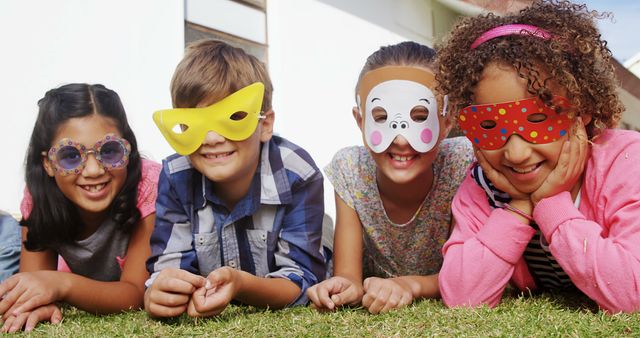 Happy Kids Wearing Fun Masks and Lying on Grass - Download Free Stock Images Pikwizard.com