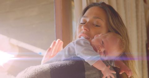 Mother Comforting Sleeping Baby With Natural Sunlight