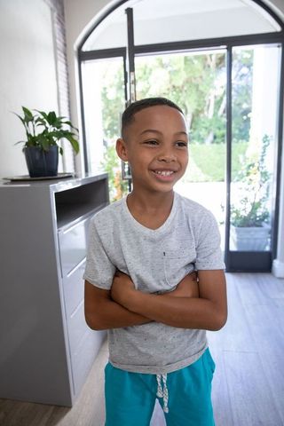Smiling Boy in Bright Entryway Hugging Himself