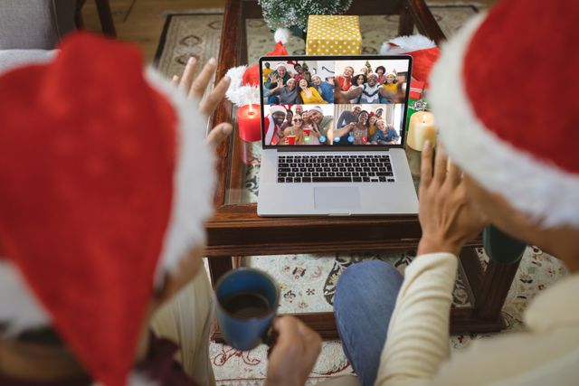 Couple with Santa Hats Having Christmas Video Call With Friends - Download Free Stock Images Pikwizard.com