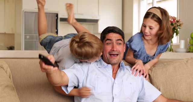 Playful Father Playing with Two Kids on Couch in Living Room - Download Free Stock Images Pikwizard.com