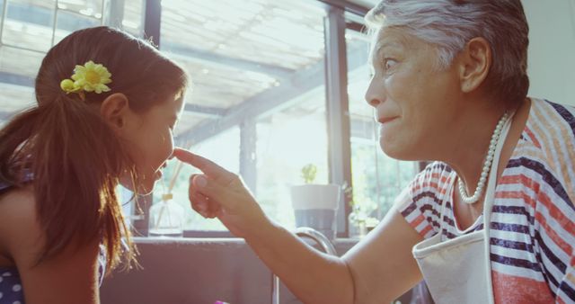 Grandmother Teasing Granddaughter in Bright Kitchen - Download Free Stock Images Pikwizard.com