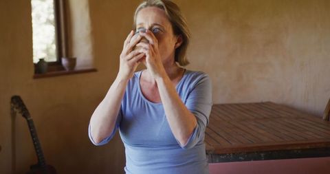 Senior Woman Enjoying Coffee in Cozy Rustic Living Room