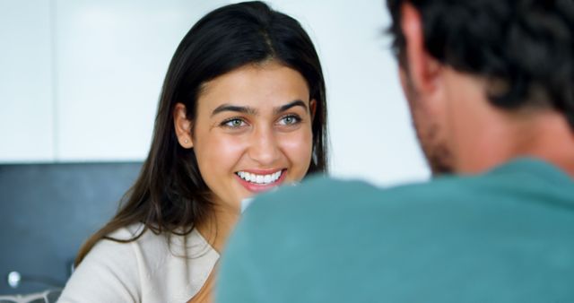 Woman smiling while having a conversation with man indoors - Download Free Stock Images Pikwizard.com