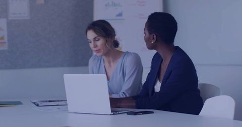 Two Businesswomen Collaborating on Project at Meeting Table