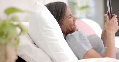 Teenage Girl Enjoying Leisure Time on Her Bed with Tablet