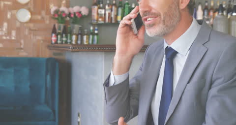 Successful Businessman on Mobile Phone in Stylish Cafe