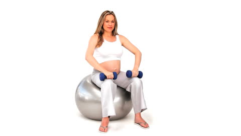 Pregnant Woman Exercising with Dumbbells on Gym Ball Blond