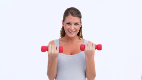 Woman Exercising with Red Dumbbells Smiling Toward Camera