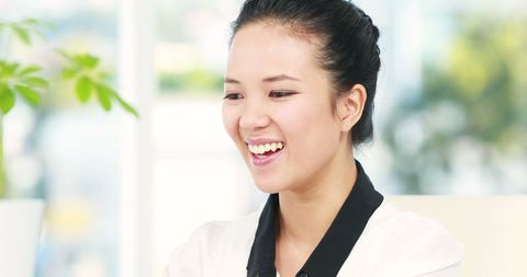 Smiling Asian Businesswoman Working in Bright Office