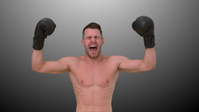 This stock video shows a boxer with arms raised in victory, celebrating a successful match. Use this video to depict themes of success, determination, and athletic achievement in sports promotions, fitness advertisements, and motivational content.