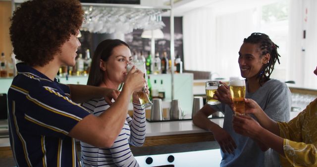 Young friends enjoying drinks and conversation at a modern bar. Perfect for concepts related to social life, nightlife, friendship, and urban living. Suitable for marketing materials for bars, nightlife events, and social media content promoting fun and leisure.