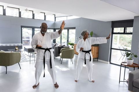 Senior Couple Practicing Karate in Stylish Home Interior