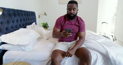 Mid Adult Man in Bedroom Checking Smartphone for Messages