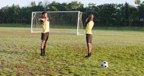 Soccer teammates stretching on field ready for match