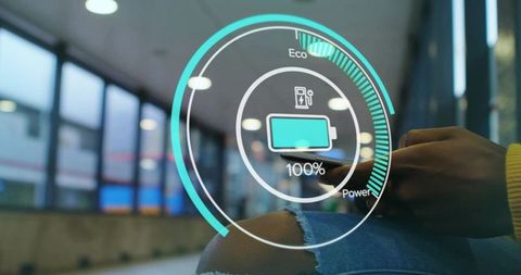 Woman holding smartphone showing augmented reality battery interface in public lounge