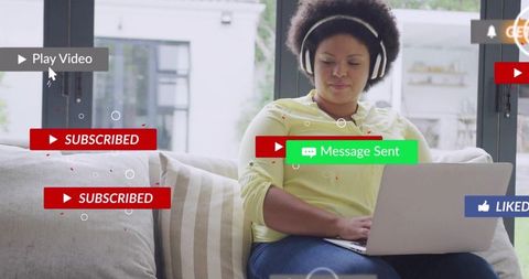 Woman listening on headphones using laptop on sofa with social media subscribe and message badges