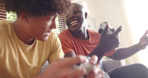 Diverse Male Friends Gaming Together on Cozy Sofa