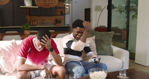 Friends Enthusiastically Gaming at Home with Snacks