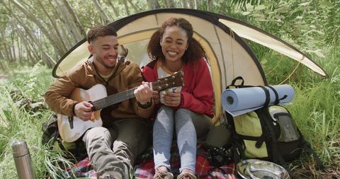 Diverse Couple Enjoying Camping Adventure in Sunny Forest
