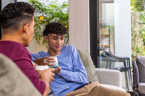 Two friends enjoying coffee in a cozy modern living room setting