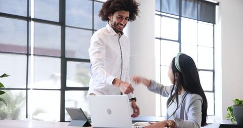 Diverse Business Team Celebrating Success with Technology in Modern Office