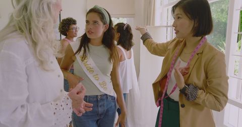 Bride-to-Be Laughing with Friends at Bright Pre-Wedding Gathering