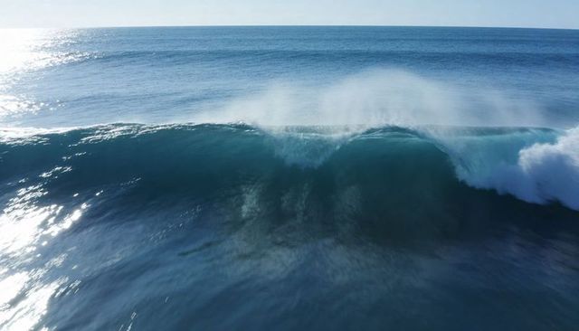 Powerful Ocean Wave Crashing and Curling with Spray, Sun Glare and Turquoise Water