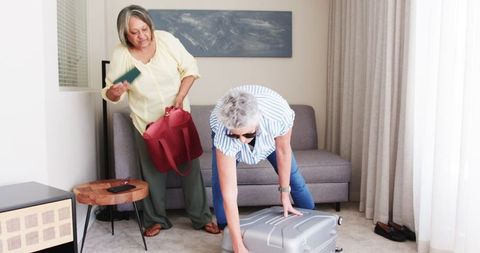 Lesbian Senior Couple Packing Suitcase for Vacation