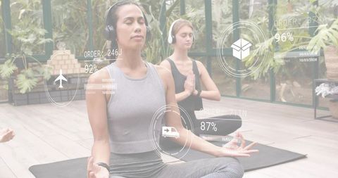 Meditating woman wearing headset and smartwatch in greenhouse yoga studio with AR overlays