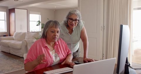 Two Senior Women Engaging with Technology at Home