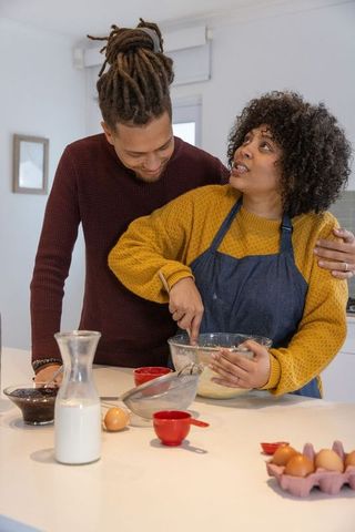 African american couple mixing batter at kitchen island sharing cozy home baking moment