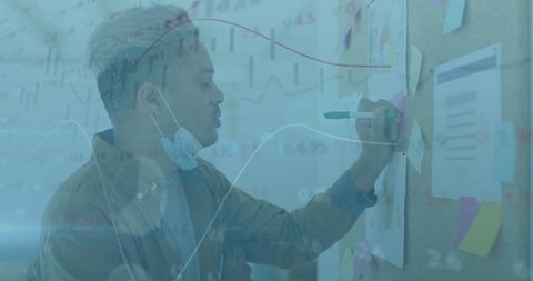 Young Professional Analyzing Financial Data with Face Mask