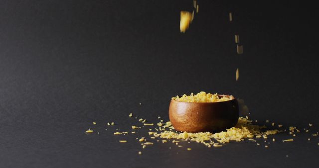 Grated Cheese Falling into Wooden Bowl Against Dark Background - Download Free Stock Images Pikwizard.com