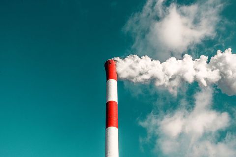 Industrial Chimney Emitting Smoke Against Clear Blue Sky