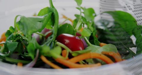 Fresh Spinach and Tomato Salad in Glass Bowl with Strainer