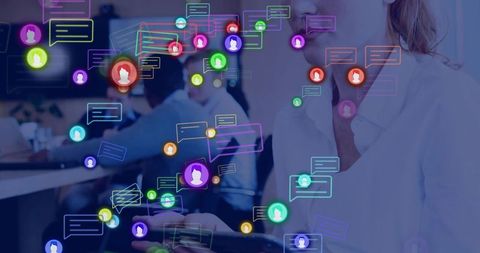 Collaborating in open office with tablet and neon chat overlays highlighting team networking
