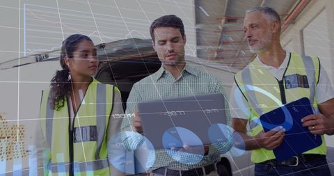Diverse Team Analyzing Data on Warehouse Floor