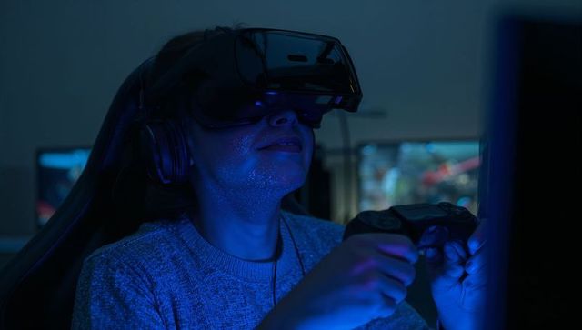Female Gamer Wearing VR Headset and Headphones Holding Game Controller in Neon Blue