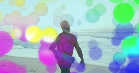 Man with yoga mat on beach amidst colorful abstract circles