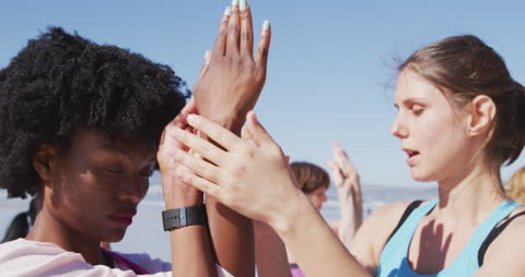 Diverse Women Practicing Yoga on Sunny Beach with Coaching