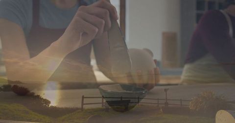 Artisan shaping pottery on turntable double exposure