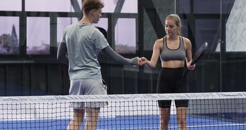 Athletes Fist Bumping at Net on Indoor Padel Court
