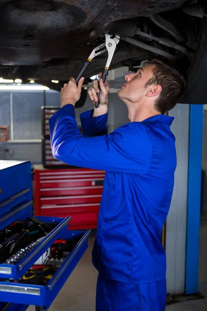 Attentive mechanic servicing a car at repair garage