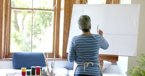 Senior Woman Engaged in Canvas Painting at Home