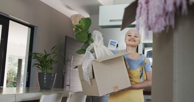 Smiling Young Woman Unpacking Boxes in New Home - Download Free Stock Images Pikwizard.com