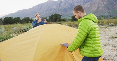 Camping adventure with yellow tent in mountainous landscape
